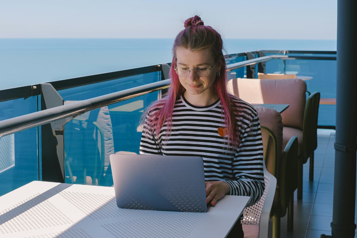 a-girl-working-on-a-laptop-by-the-water